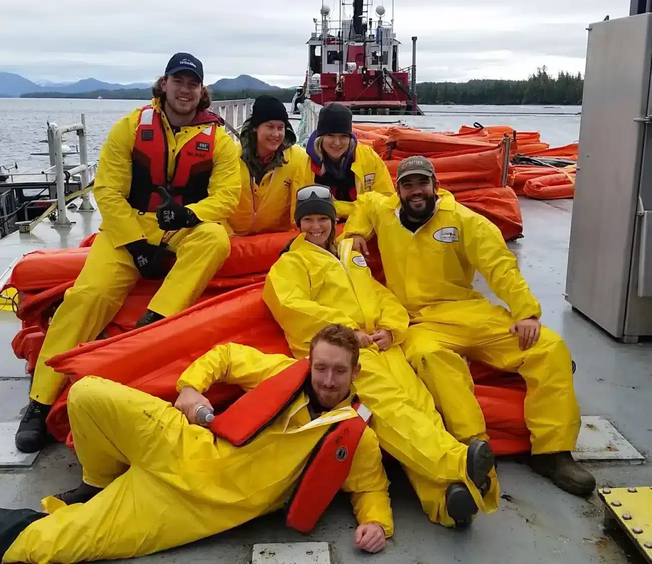 Spill response team wearing yellow rain jackets and orange PFDs grouped together for a photo